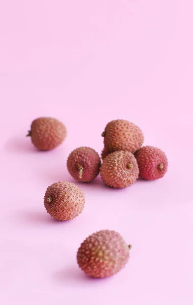 Fresh litchi fruits on a light pink backgrpund