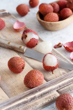Fresh litchi fruits with a knife clipart