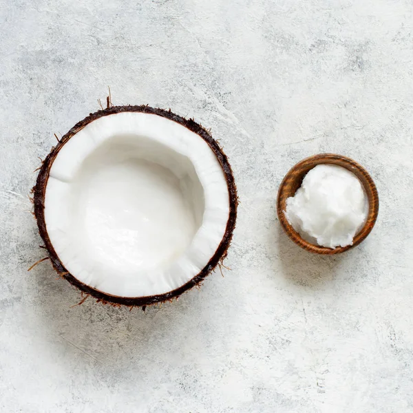 Кокосовое масло в миске и половина кокоса — стоковое фото