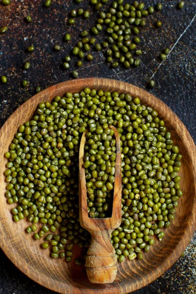 Frijoles mungo secos con una cuchara sobre un fondo oscuro —  Fotos de Stock