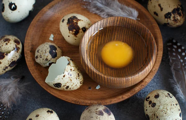 Huevos de codorniz en un plato de madera sobre un fondo gris oscuro — Foto de Stock