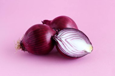 Açık pembe arka planda mor soğan. Yakın plan.