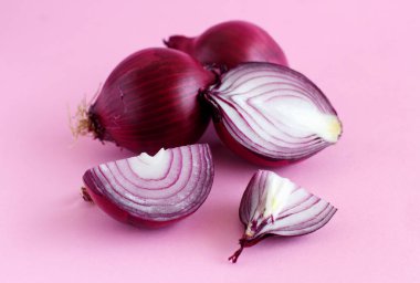 Açık pembe arka planda mor soğan. Yakın plan.