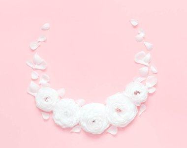 Açık pembe arkaplan manzaralı ranunculus çiçeklerinden yapılmış daire çerçeve. Bahar konsepti