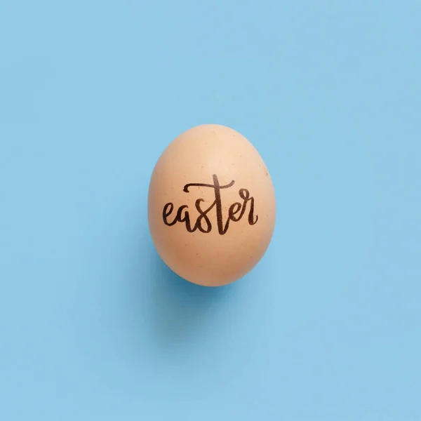 Uovo Con Iscrizione Pasqua Sfondo Azzurro Vista Dall Alto Concetto — Foto Stock