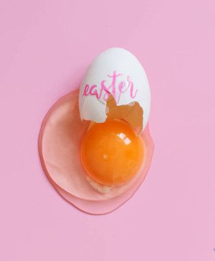 Kırık yumurta ve pembe arka plan görünümlü el yazması Paskalya.
