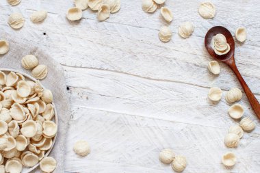 Tahta bir masanın üstünde tam buğday unundan yapılmış taze apulian makarnası.