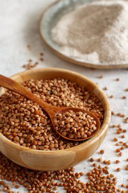 Karabuğday lapası ve un kaselerde, kaşıkla yakın plan. 