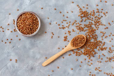 Kaşık görünümlü bir kasede çiğ karabuğday taneleri.