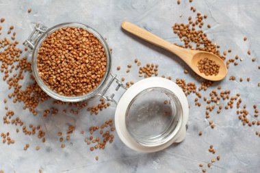 Kavanozda çiğ karabuğday taneleri ve kaşık manzarası.