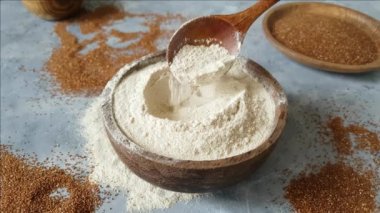 Bir kâsede un, bir kaşık ve tahılla. 