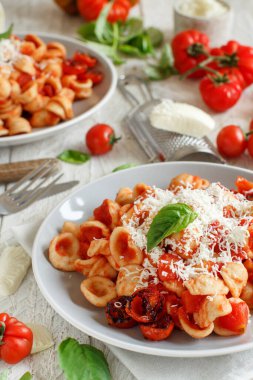 Domates soslu ve cacioricotta peynirli Güney İtalya makarnası. Beyaz bir masaya yakın. 