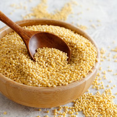 Tahta bir kâse içinde, içi boş bir kaşıkla çiğ, gövdeli darı.