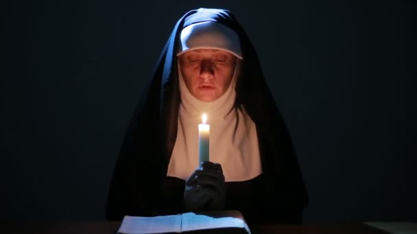 女人修女在夜间祈祷。燃烧的蜡烛。女人的衣服修女 — 图库视频影像