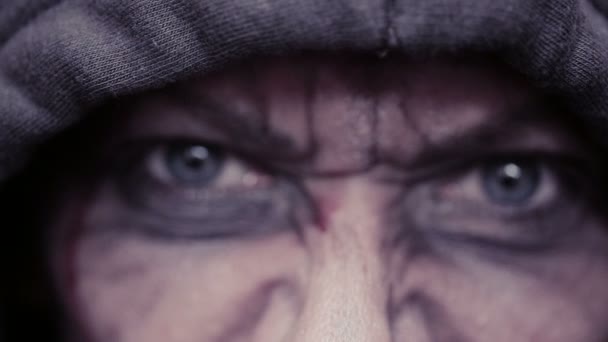 Mad eyes of an evil man. Dirty face in blood. head in the hood — Stock Video