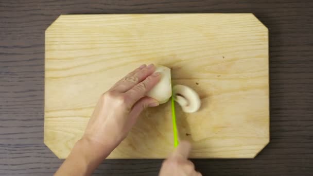 Женщина режет грибы на деревянном столе. Шампиньон — стоковое видео
