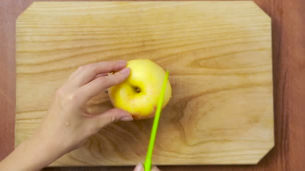 Kvinna skär ett äpple på en träskiva. laga mat — Stockvideo