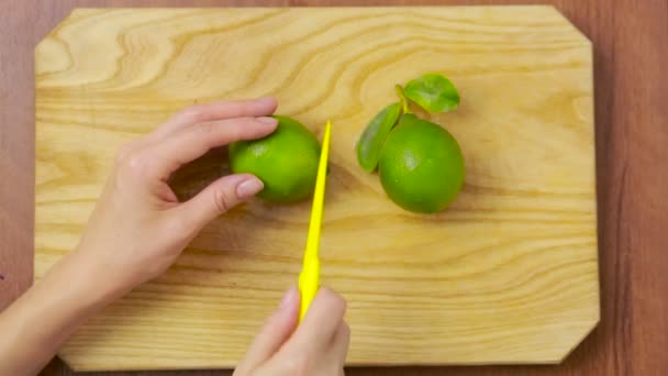 Mani delle donne che tagliano lime verde fresco. vista dall'alto — Video Stock