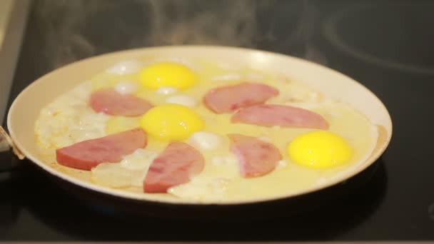 Smažená vajíčka se šunkou v kastrolku na snídani. Vaření — Stock video