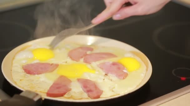 Smažená vajíčka se šunkou v kastrolku na snídani. Vaření — Stock video