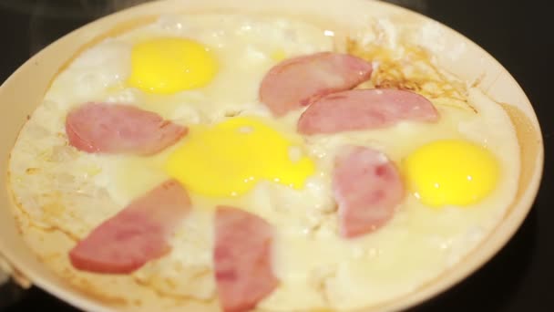 Fried eggs and ham in a pan for breakfast. Cooking — Stock Video