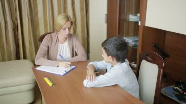 Genç çocuk sessizce oturumu sırasında genç psikolog ile oturuyor..