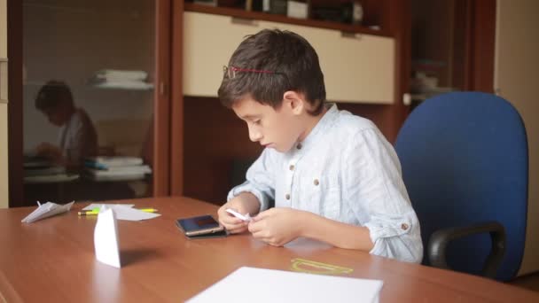 Mały chłopiec rysujący na papieru sztuki origami. hobby rzemiosła — Wideo stockowe