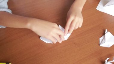 Küçük çocuk kağıt sanat origami üzerinde çizim. hobi el sanatları