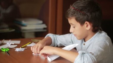 Küçük çocuk kağıt sanat origami üzerinde çizim. hobi el sanatları