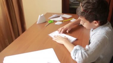 Küçük çocuk kağıt sanat origami üzerinde çizim. hobi el sanatları