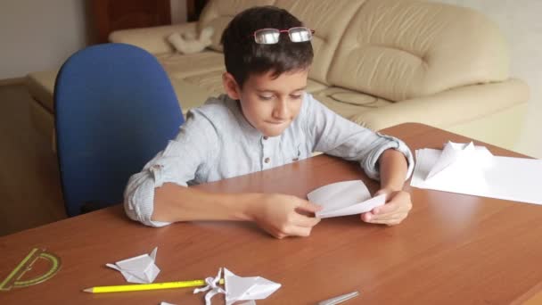 Маленький хлопчик малює на паперовому мистецтві орігамі. ремесла для хобі — стокове відео