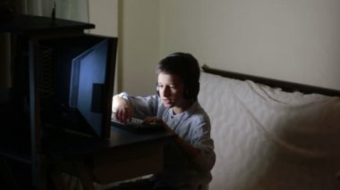 Genç çocuk geceleri üstünde bilgisayar oyunları oynar. Online Oyunlar