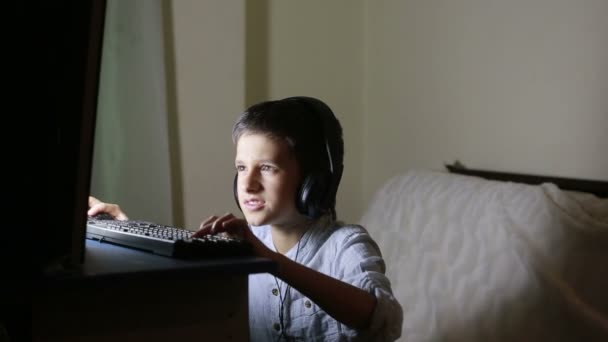 Teen pojke spelar spel på datorn på natten. Onlinespel — Stockvideo