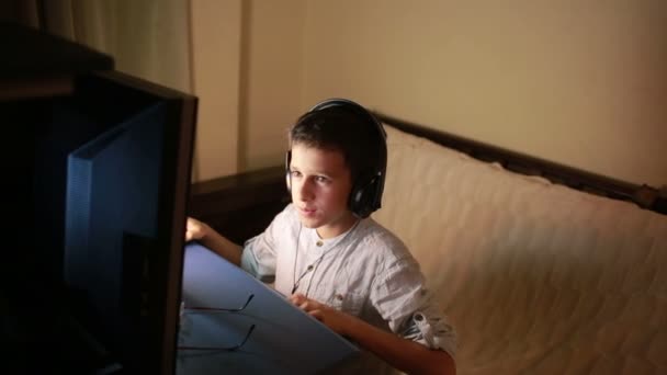 Мальчик-подросток играет в игры за компьютером ночью. Онлайн игры — стоковое видео