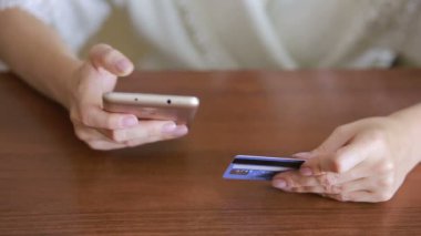 kadın bir smartphone ve banka kartı kullanarak bir satın alma işlemi yaptığı.