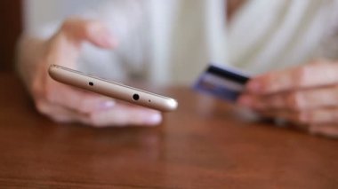 kadın bir smartphone ve banka kartı kullanarak bir satın alma işlemi yaptığı.