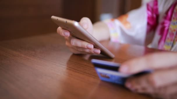 Woman makes a purchase using a smartphone and a bank card. — Stock Video