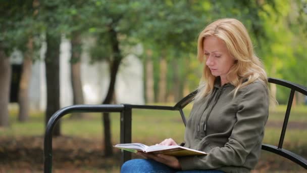 szőke nő olvasókönyv a fogorvostudomány őszi parkban.