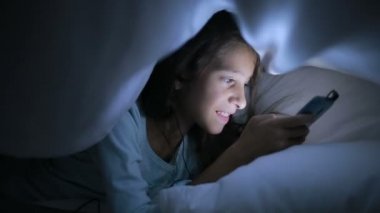 Geceleri bir cep telefonu kullanan küçük kız