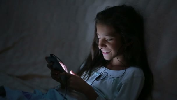 Niña usando un teléfono celular por la noche — Vídeos de Stock