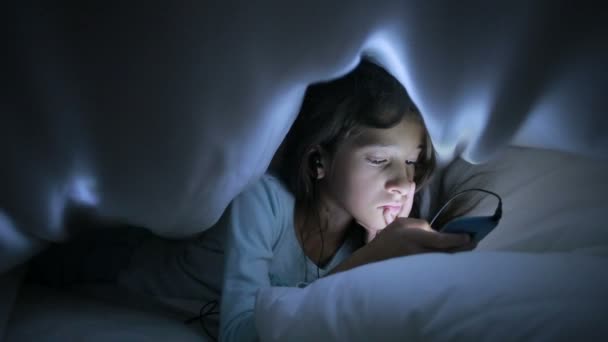Bambina utilizzando un telefono cellulare di notte — Video Stock