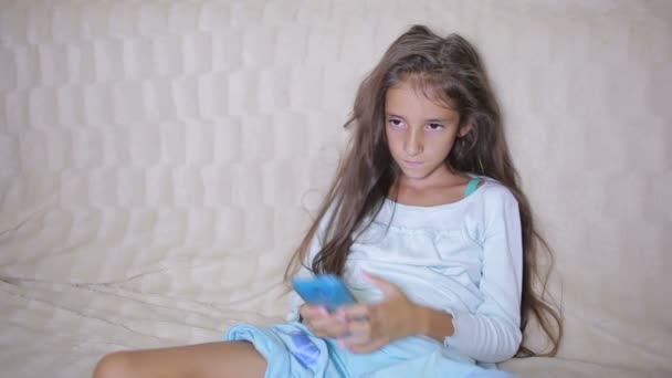 Meisje kind met een mobiele telefoon gegevens zoekt op het Internet — Stockvideo
