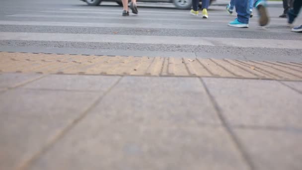 Fußgängerüberweg. Menschen überqueren die Straße. Füße auf dem Bürgersteig. — Stockvideo
