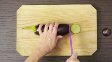 Kadın kesme patlıcan ahşap tahta üzerinde eller. Yukarıdan görüntüleyin. Üstten Görünüm