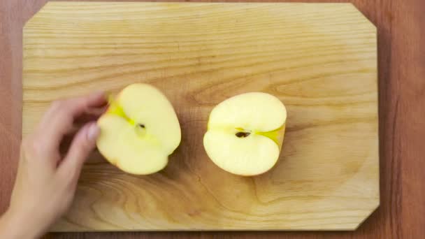 Vrouw snijdt een appel op een houten bord. koken voedsel. bovenaanzicht — Stockvideo