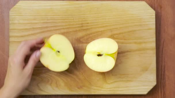 Femme coupe une pomme sur une planche de bois. cuisiner. vue de dessus — Video