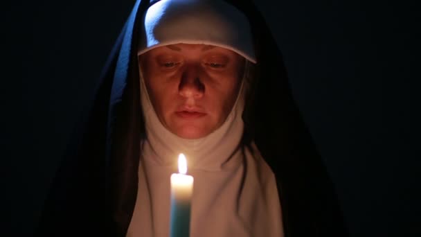 Жінка черниця молиться вночі. палаючі свічки. Жінка в одязі черниці — стокове відео