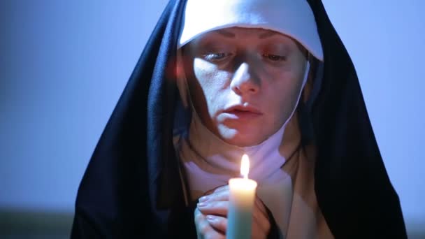 Kvinna nunna ber på natten. brinnande ljus. Kvinna i kläder nunnor — Stockvideo