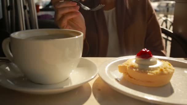 Mujer comiendo pastel en la cafetería al aire libre. primer plano pastel de queso — Vídeos de Stock