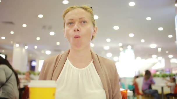 Женщина в супермаркете пьет кофе. жевательная пища — стоковое видео